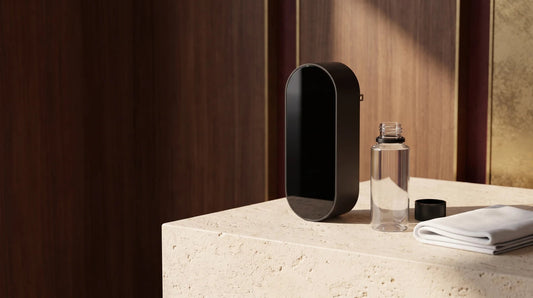 Black plug-in waterless diffuser beside a separate refill bottle and microfiber cloth