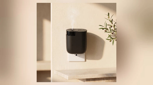 Black Contour Smart Plug-In waterless diffuser installed above a warm stone counter
