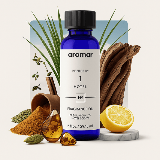 A bottle of '1 Hotel inspired' fragrance oil with various botanicals and spices around it, including lemon, vanilla, and cardamom.