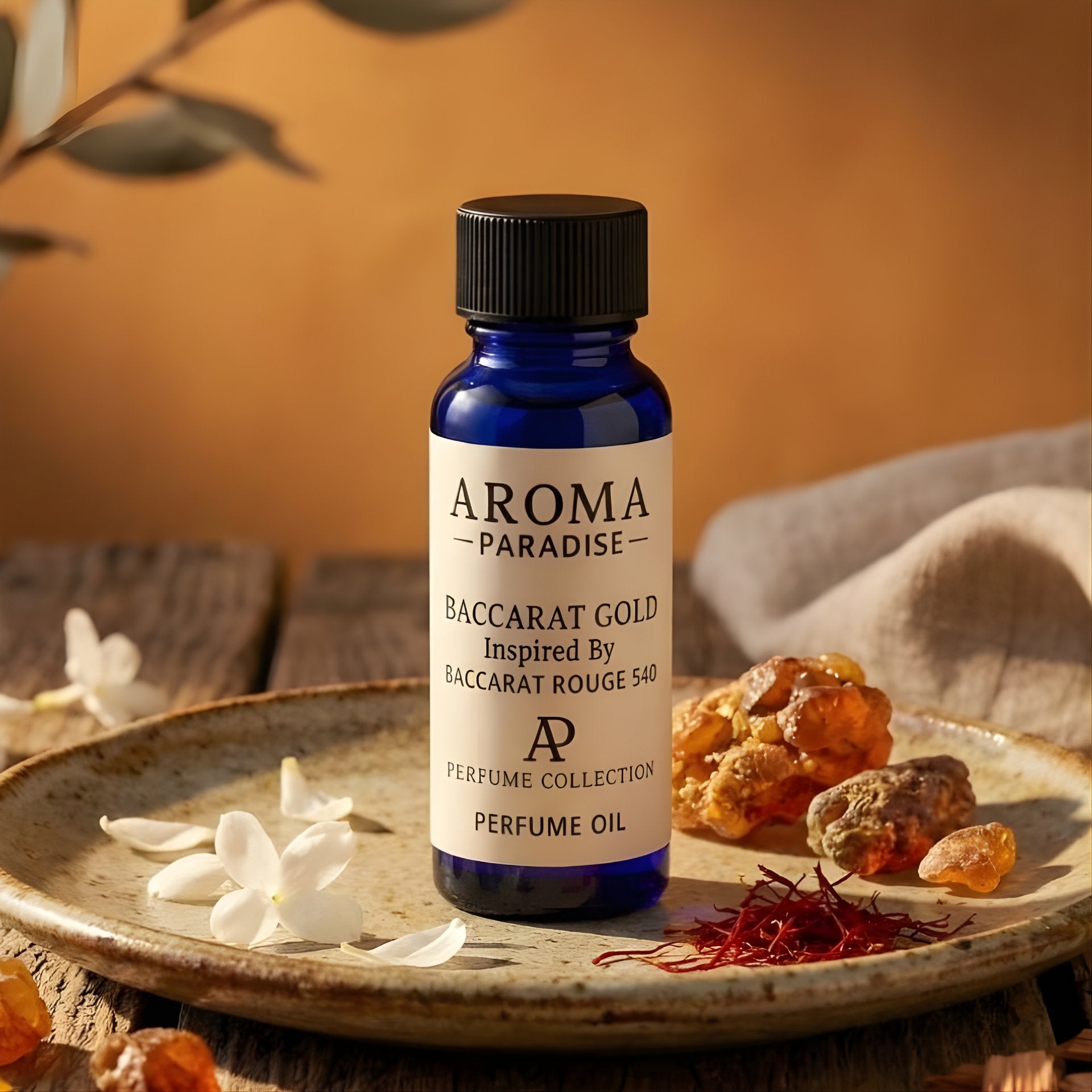 Bottle of Aroma Paradise Baccarat Gold perfume oil on a wooden surface with saffron and flowers.