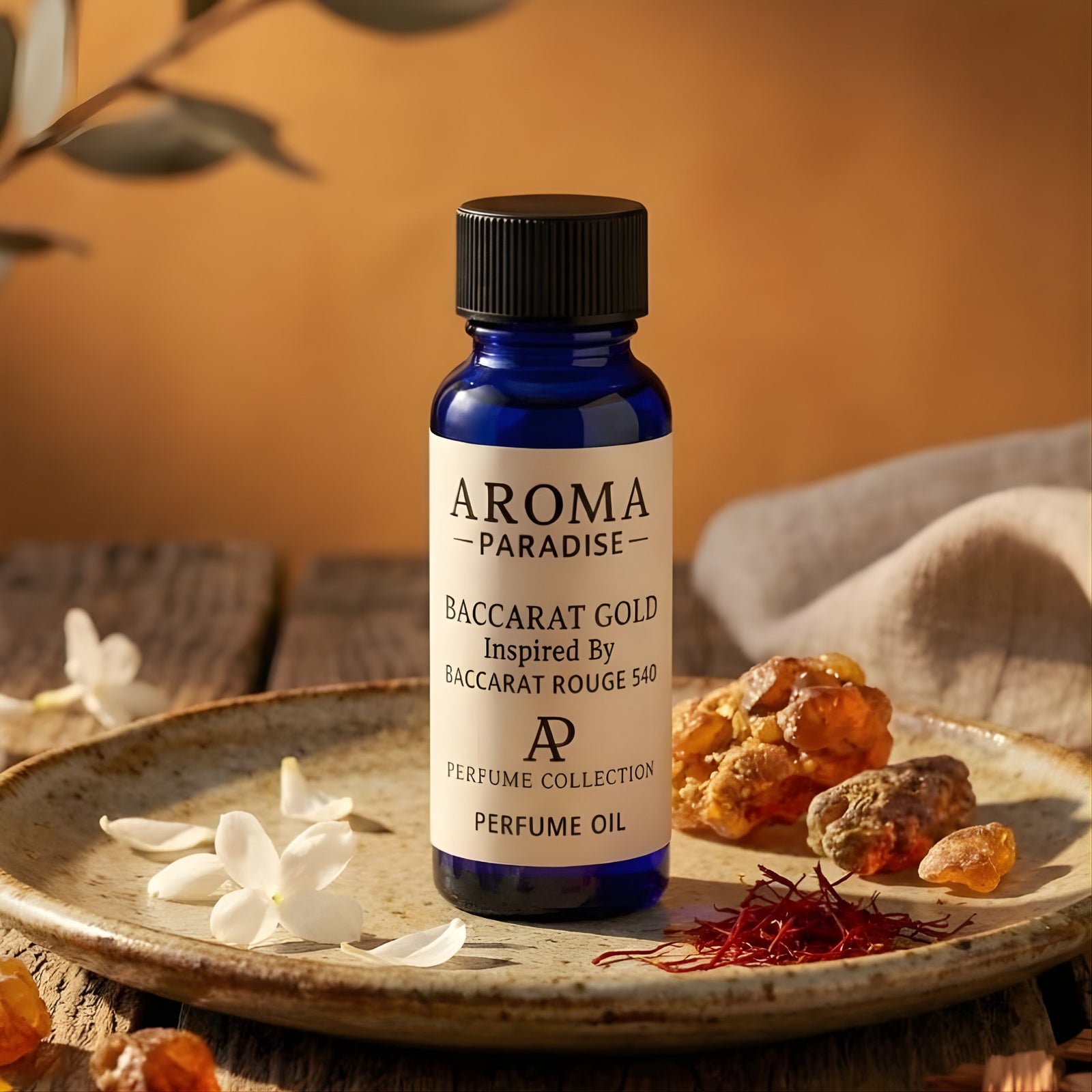 Bottle of Aroma Paradise Baccarat Gold perfume oil on a wooden surface with saffron and flowers.