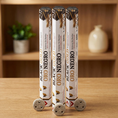 Aum Black and Gold bambooless incense sticks 3-pack with 3 metal coil holders on light oak wood surface