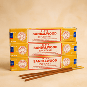 Three boxes of Satya Sandalwood Incense on a beige background