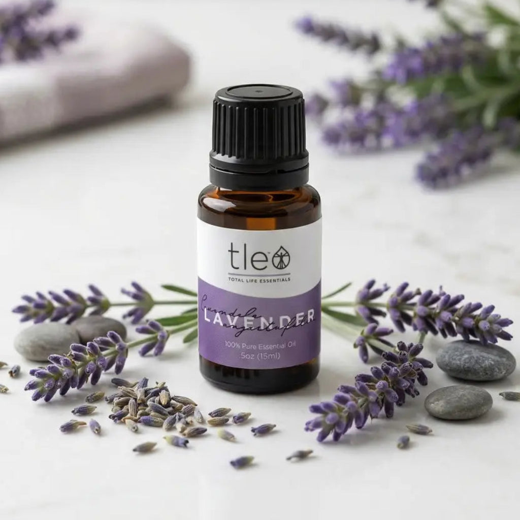 Lavender essential oil bottle with lavender flowers and stones on a light surface