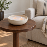 Candle sand in an ivory bowl on a raised walnut side table