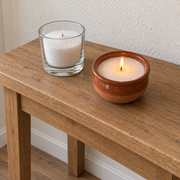 Candle sand in glass and ceramic vessels on an oak console table