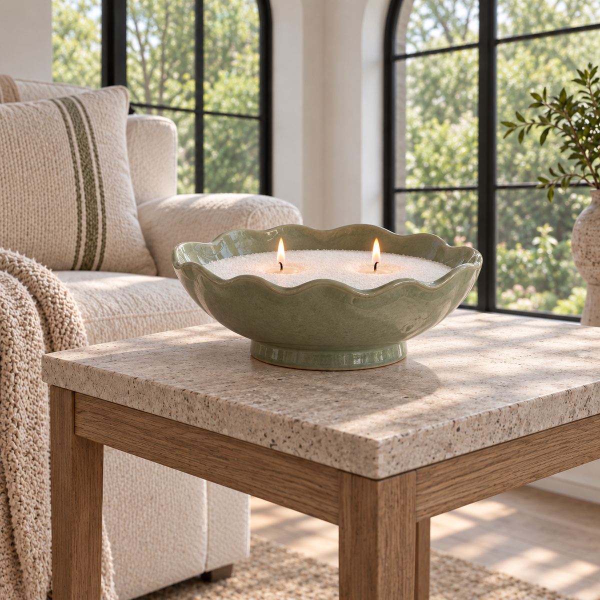 Candle sand in a sage bowl on a raised stone-topped side table