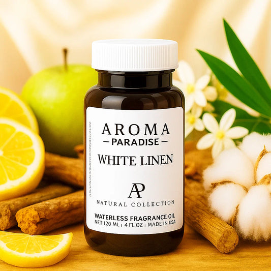 Bottle of Aroma Paradise White Linen fragrance oil with lemons, apples, and cotton in the background