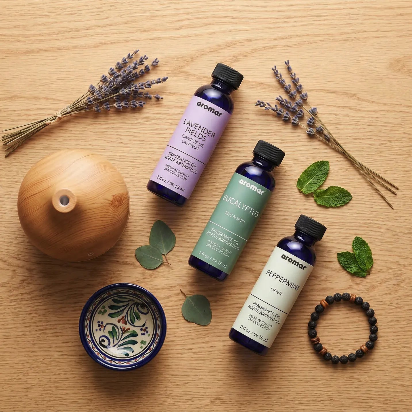 Relaxing oil set flat lay with wood diffuser dried lavender mint leaves and lava bracelet, Aroma Paradise
