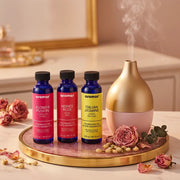 Floral oil set with gold diffuser misting on pink marble tray with dried roses on elegant vanity, Aroma Paradise