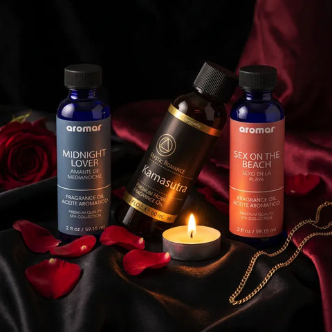 Three romantic fragrance oil bottles with rose petals and lit tealight on dark satin fabric - Aroma Paradise
