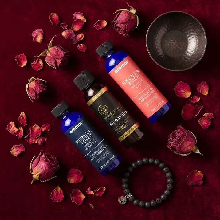 Romantic Fragrance Oil Set flat lay with dried roses, bead bracelet, and copper bowl on velvet - Aroma Paradise