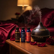 Romantic Fragrance Oil Set on nightstand with diffuser, rose petals, and cozy bedroom setting - Aroma Paradise