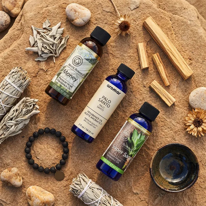 Good Luck Fragrance Oil Set flat lay with sage bundle, palo santo, bracelet on sandy surface - Aroma Paradise