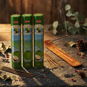 Hem Coconut incense green tubes with smoking stick in wooden holder on rustic wood with eucalyptus - Aroma Paradise