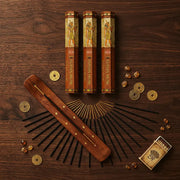 Hem Egyptian Musk incense flat lay with three tubes, wooden holder, sticks, and coins on dark wood - Aroma Paradise