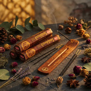 Hem Sandalwood incense boxes with smoking stick in wooden holder on dark stone with dried roses - Aroma Paradise