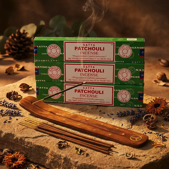 Three green Satya Patchouli incense boxes with smoking stick on wooden holder and dried flowers - Aroma Paradise