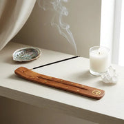 Satya White Sage incense burning on wooden holder with candle and crystals on white shelf - Aroma Paradise