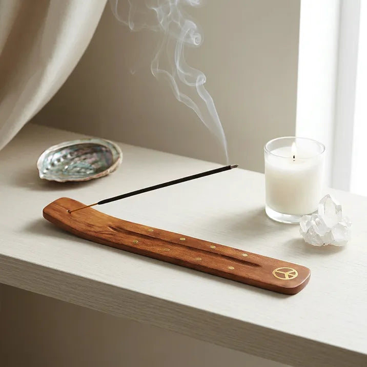 Satya White Sage incense burning on wooden holder with candle and crystals on white shelf - Aroma Paradise