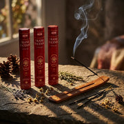 Three dark red Hem Frankincense boxes with smoking stick in wooden holder on stone surface - Aroma Paradise