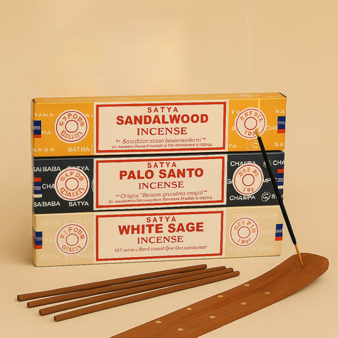 Satya sandalwood, palo santo, and white sage incense packaging with incense sticks and a wooden incense holder on a beige background.