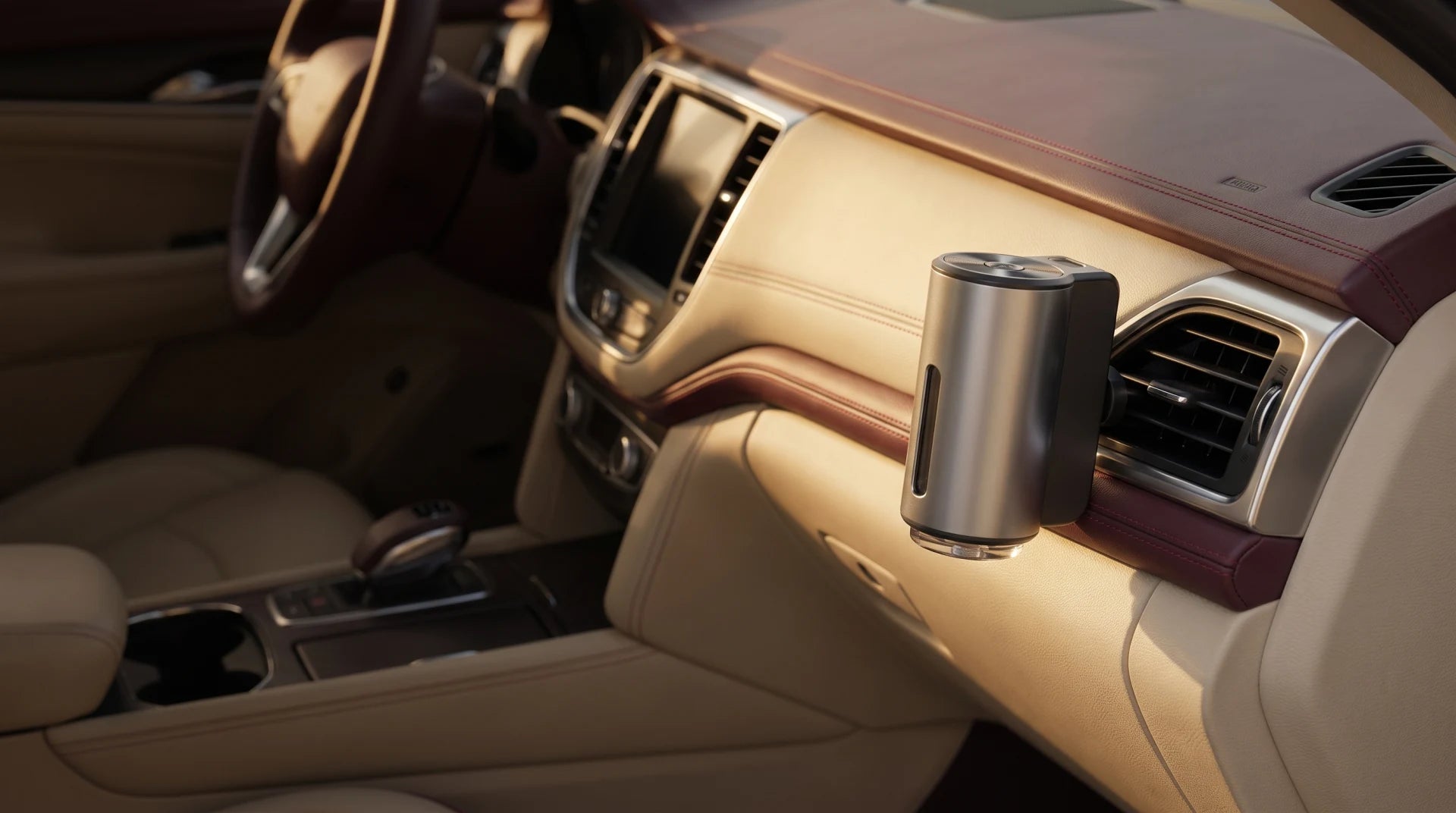 Compact silver scent diffuser mounted securely on a car air vent